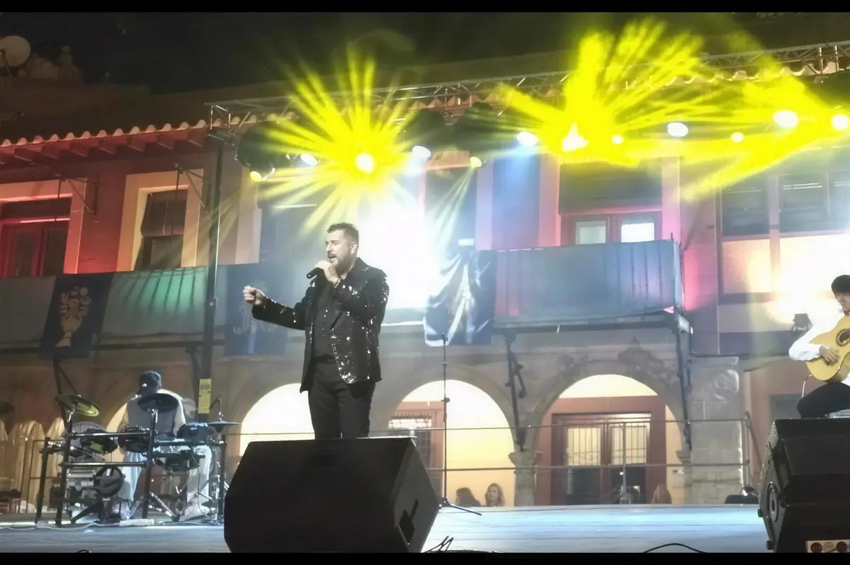 Cantante en el escenario de La Solana con haces de luz amarillos